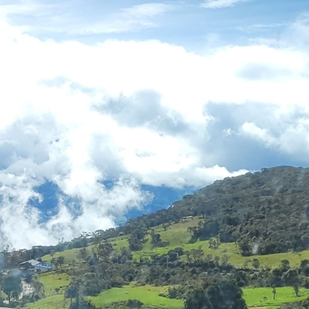 Green Cundinamarca hillsides under low cloud, seen from the road out of Bogota